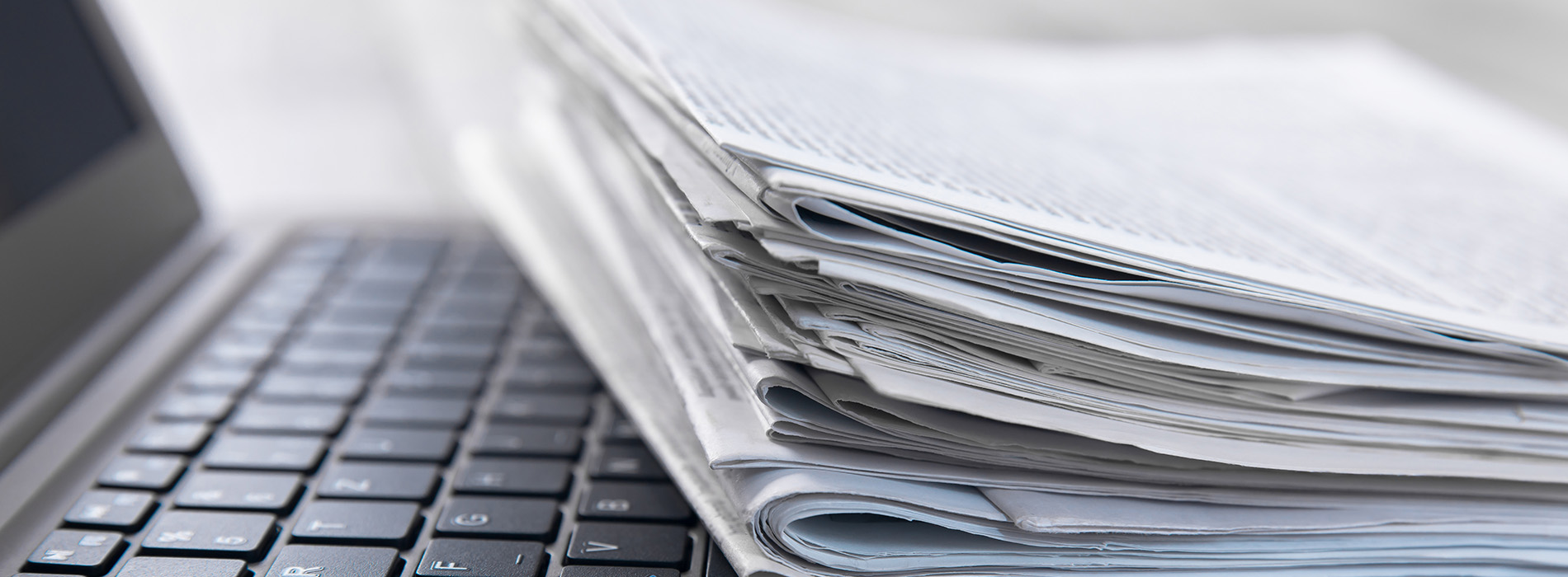 The image shows a stack of papers on top of a laptop computer.
