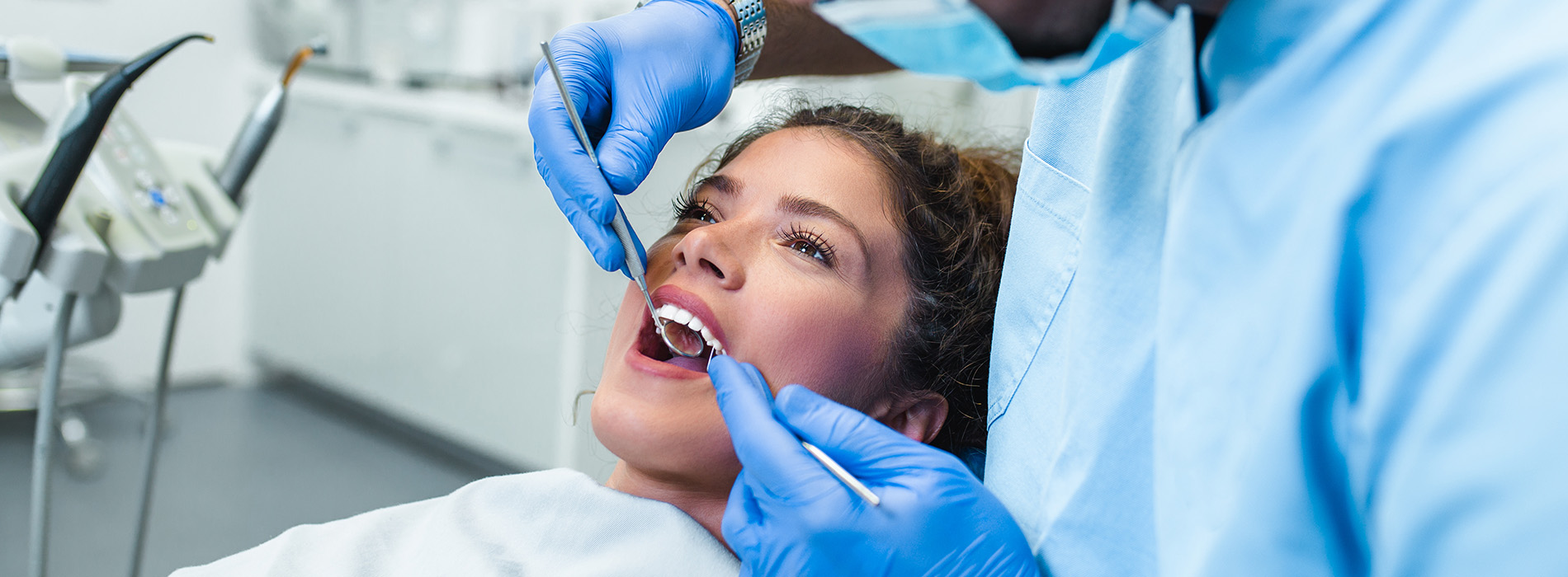 A well-lit reception area with a desk, computer monitor, and potted plant.