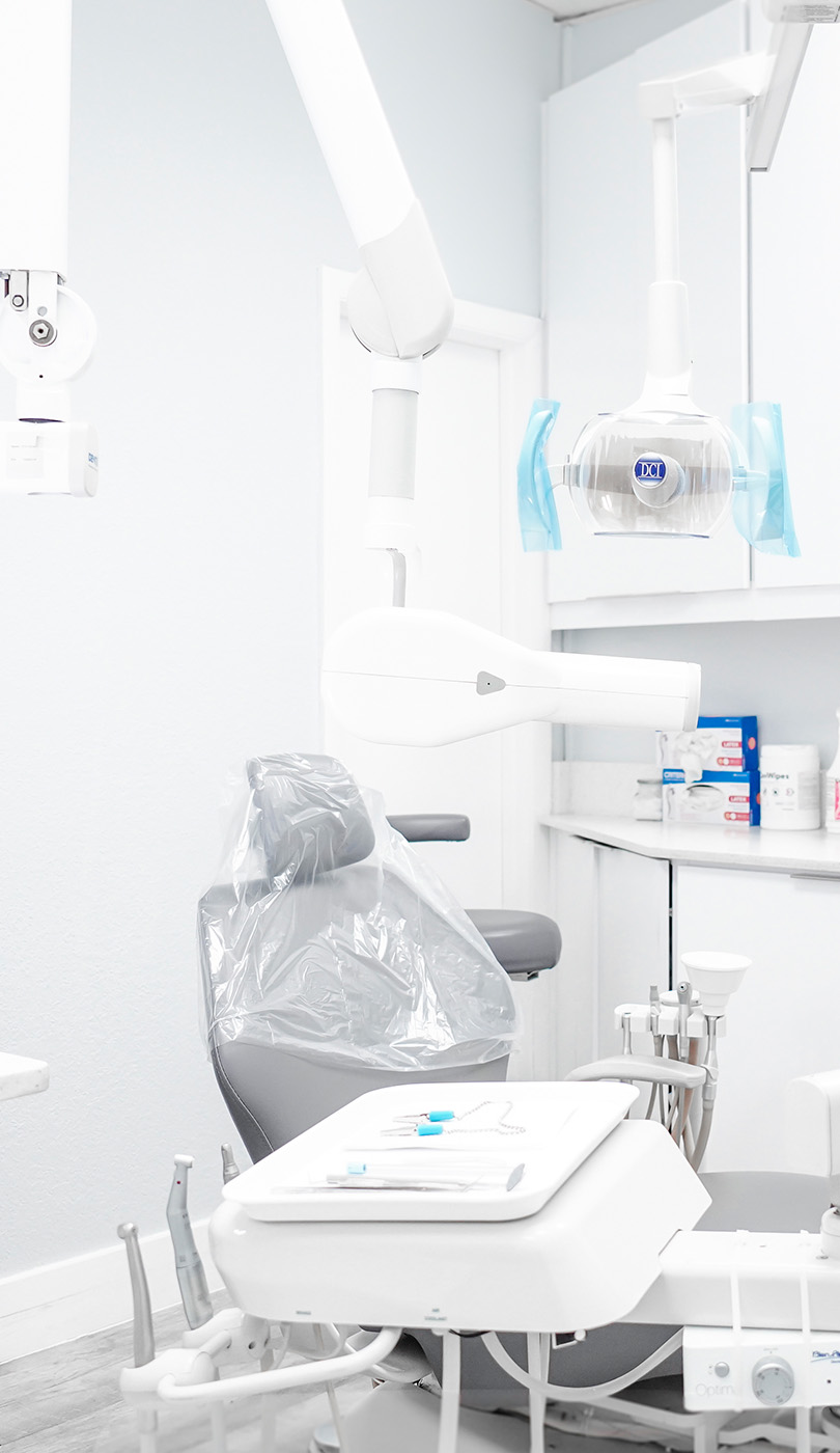 The image shows a modern dental or medical office interior with a dental chair, equipment, and a clean, professional environment.