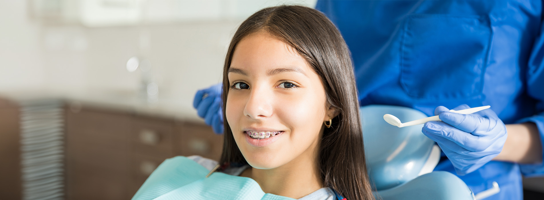 A young girl receiving dental care from a professional, with the setting suggesting a dental office environment.